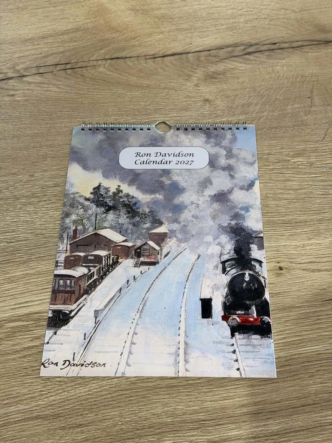 The Ron Davidson 2027 calendar, with a snowy steam train painting on the cover